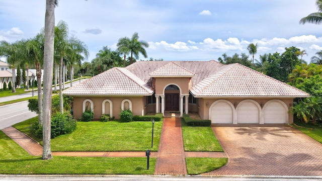 mediterranean / spanish-style house featuring a front yard and a garage