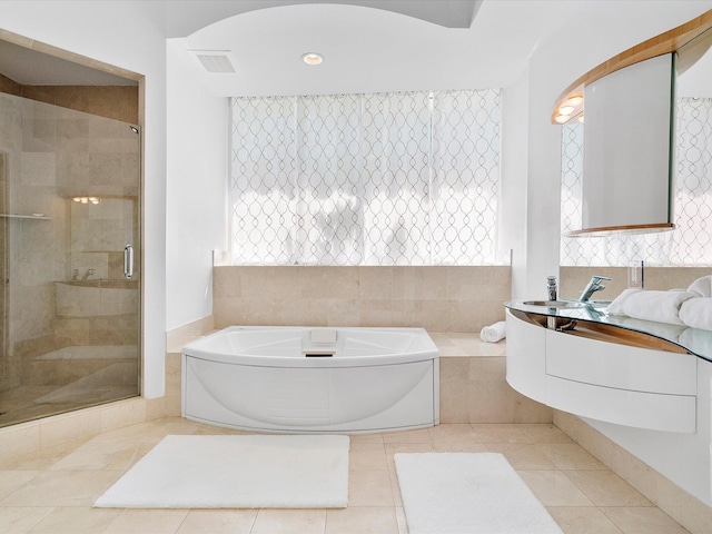 bathroom with shower with separate bathtub and tile flooring