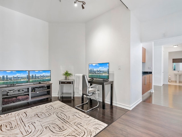 home office with rail lighting and dark wood-type flooring