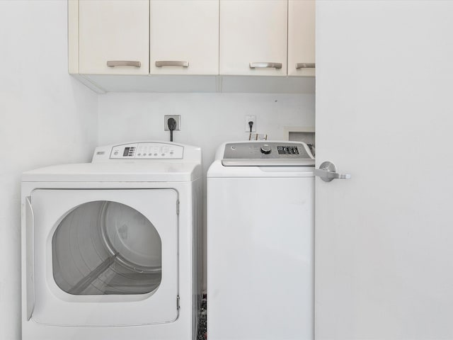 laundry area with hookup for a washing machine, cabinets, washer and dryer, and hookup for an electric dryer