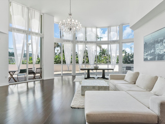 living room featuring a notable chandelier, dark wood-type flooring, and a towering ceiling