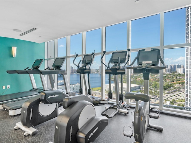 gym with a water view and a wall of windows