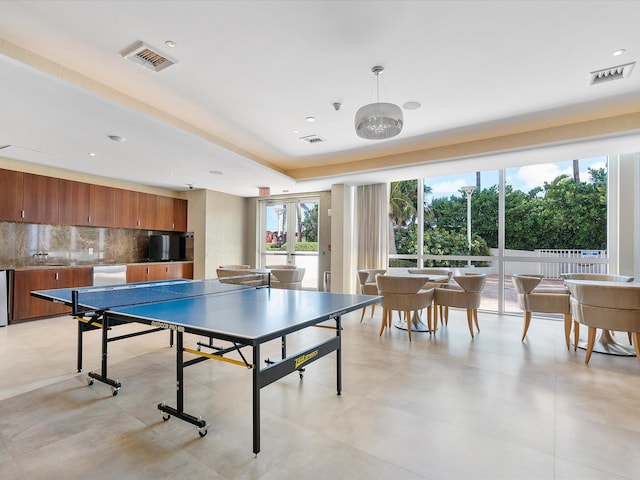 game room featuring sink, a notable chandelier, and light tile flooring