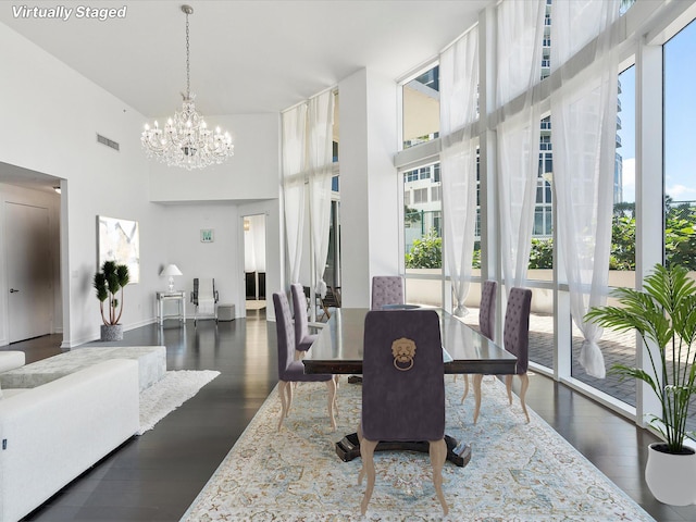 dining room with an inviting chandelier, dark hardwood / wood-style flooring, and a healthy amount of sunlight