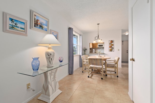 tiled dining space with a textured ceiling