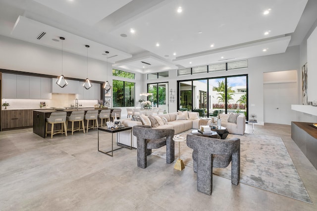 tiled living room featuring plenty of natural light, beam ceiling, and sink