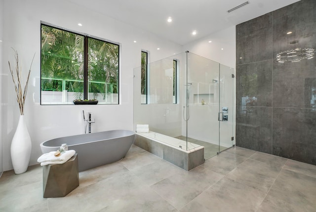 bathroom featuring plenty of natural light, tile flooring, and separate shower and tub