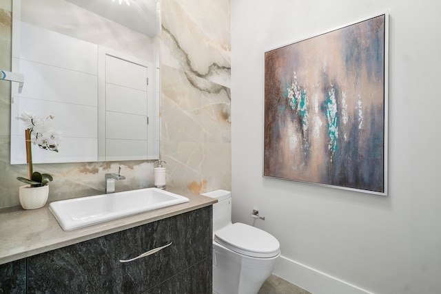 bathroom with tile walls, toilet, and vanity