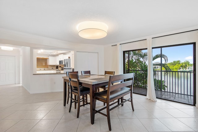 dining area with crown molding and light tile floors