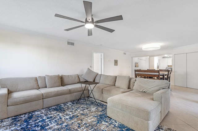 living room featuring ornamental molding, a textured ceiling, ceiling fan, and light tile floors