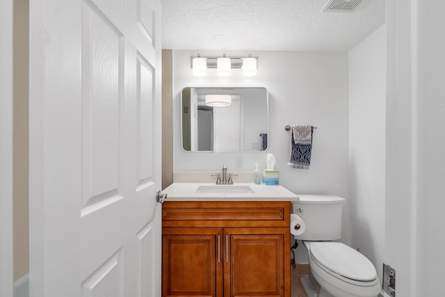 bathroom featuring tile floors, toilet, a textured ceiling, and vanity