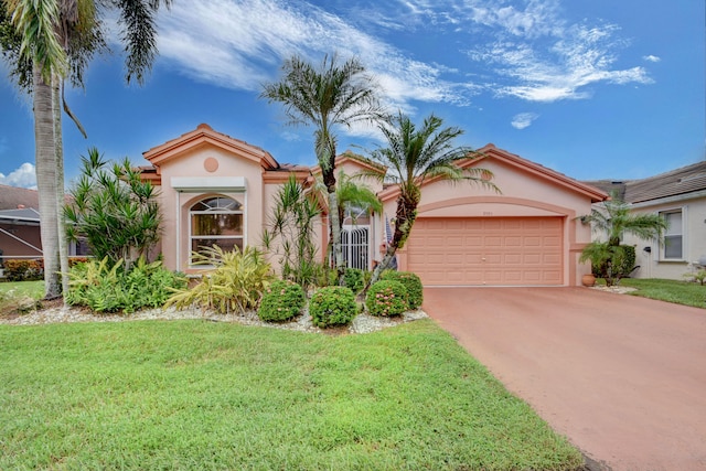 mediterranean / spanish-style house featuring a front yard and a garage