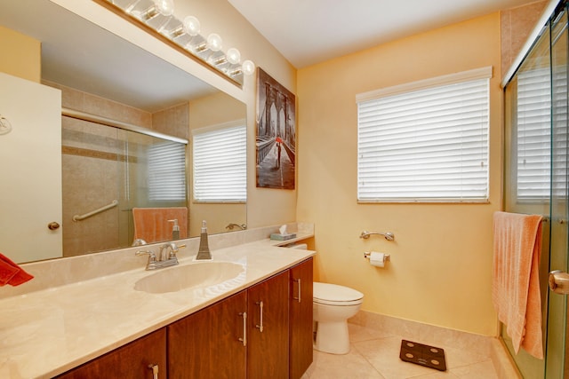 bathroom featuring toilet, tile floors, a shower with shower door, and vanity