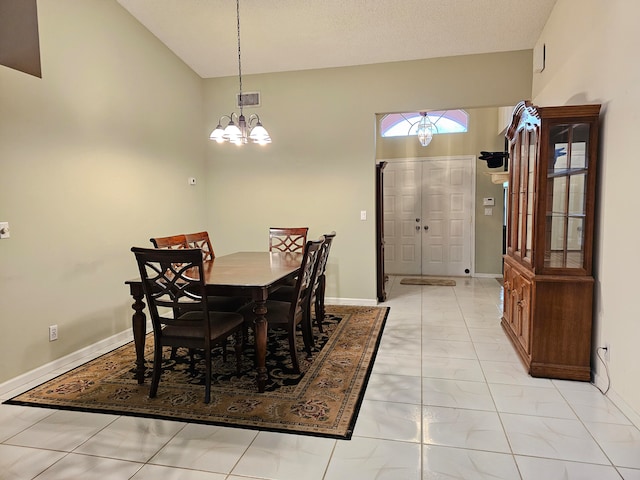 tiled dining room with a high ceiling, a notable chandelier, and a textured ceiling