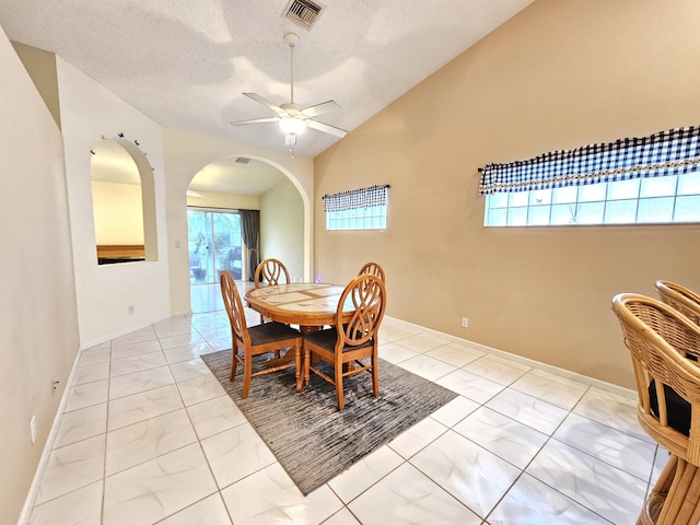 dining space with lofted ceiling, ceiling fan, and light tile floors