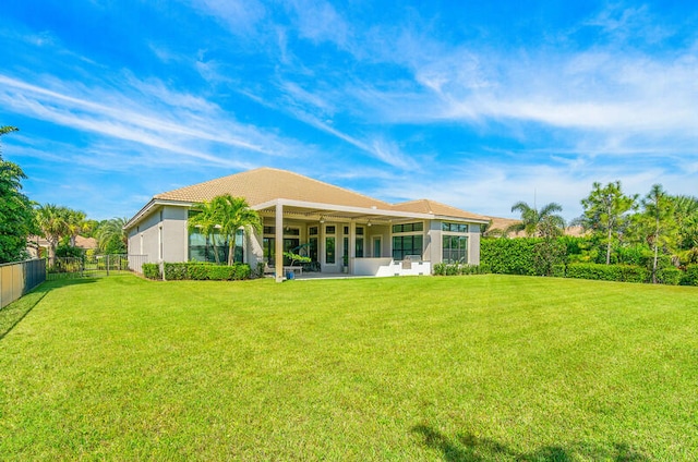 back of house with a lawn and a patio area