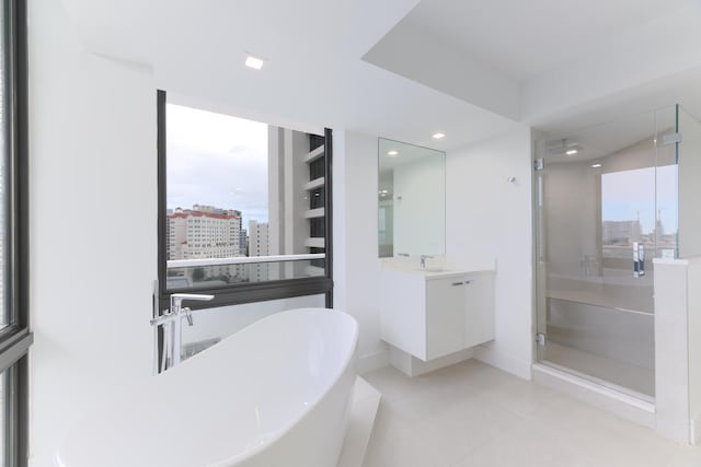 bathroom featuring shower with separate bathtub, vanity, and tile flooring