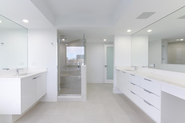 bathroom with tile flooring, walk in shower, and vanity