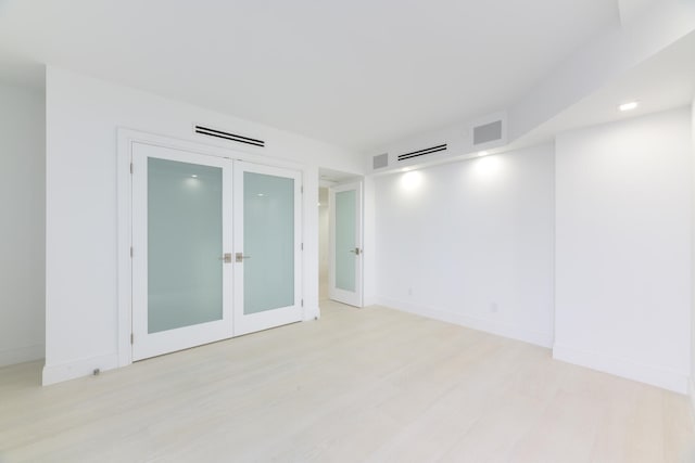 empty room with french doors and light wood-type flooring