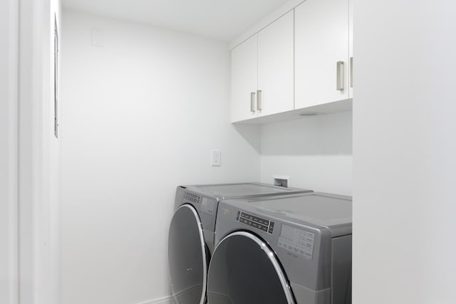 laundry area featuring hookup for a washing machine, cabinets, and washer and dryer