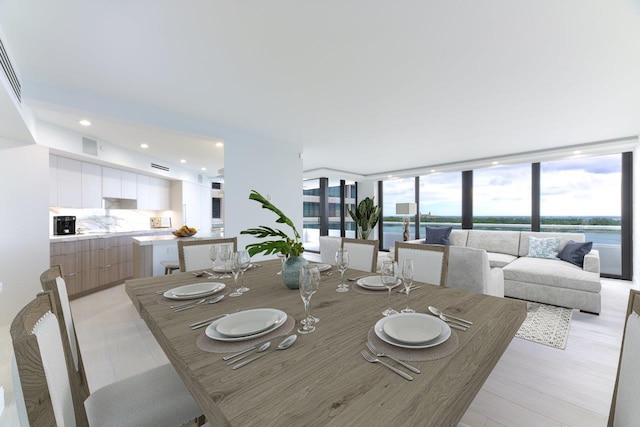 dining area featuring a water view and floor to ceiling windows