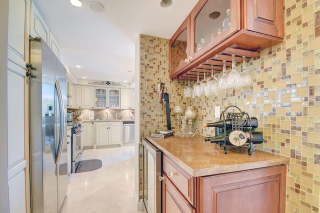 kitchen with glass insert cabinets, wine cooler, decorative backsplash, white cabinets, and stainless steel appliances