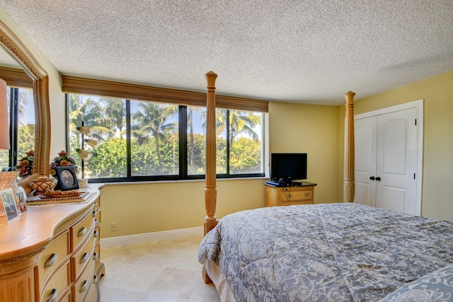 bedroom with a closet, multiple windows, and a textured ceiling