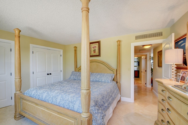 bedroom featuring visible vents, baseboards, a textured ceiling, and a closet