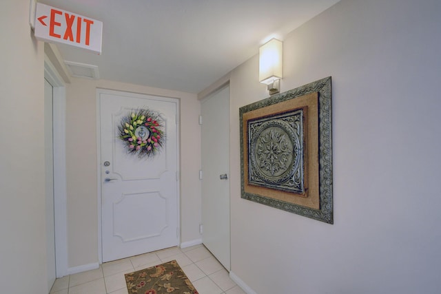 foyer featuring light tile patterned floors and baseboards