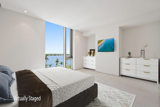 bedroom with expansive windows and a water view