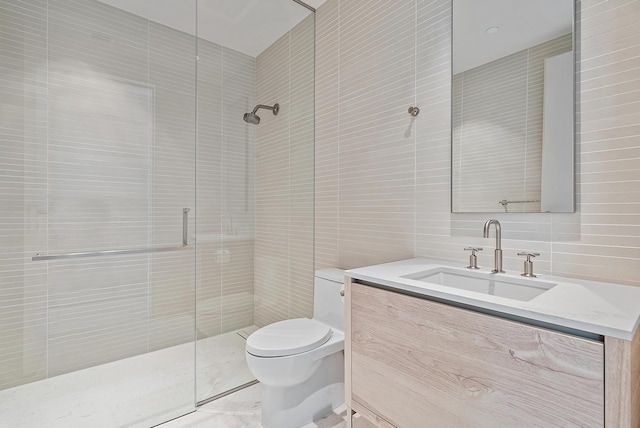 bathroom featuring vanity, a shower with shower door, toilet, and tile walls