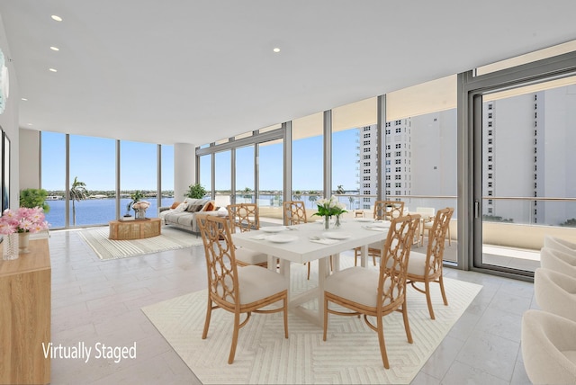 tiled dining area featuring a water view and floor to ceiling windows