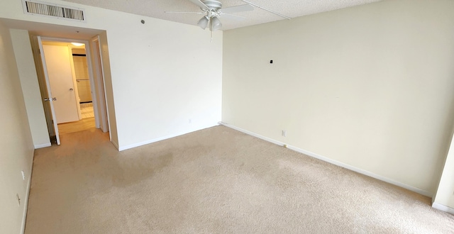 unfurnished room featuring a textured ceiling, light colored carpet, and ceiling fan