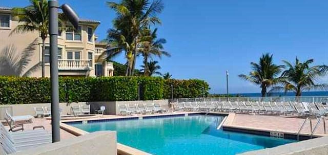 view of pool with a patio and a water view