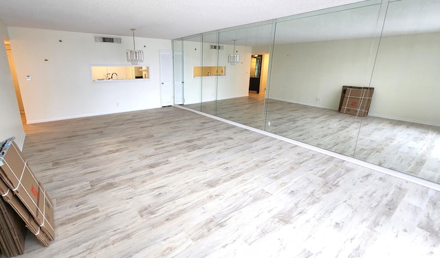 unfurnished room with hardwood / wood-style floors and a textured ceiling