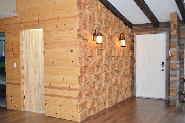 interior space featuring wood walls, dark hardwood / wood-style floors, and lofted ceiling with beams