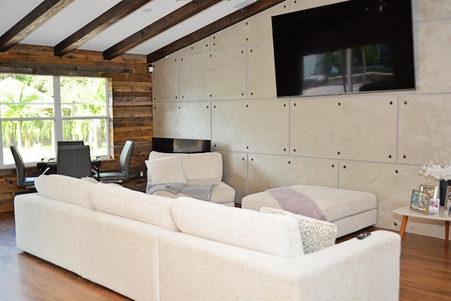 living room with wooden walls, vaulted ceiling with beams, and light hardwood / wood-style floors