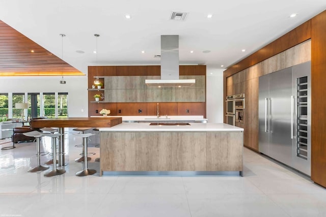 kitchen with island range hood, a breakfast bar, pendant lighting, and a kitchen island