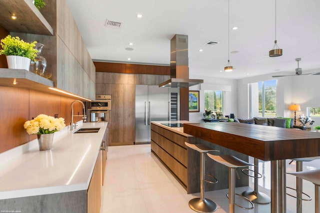 kitchen featuring island range hood, a large island, light tile patterned floors, and stainless steel appliances