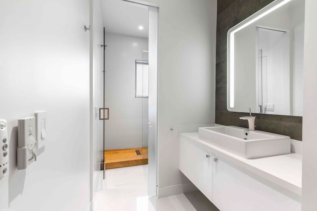 bathroom with a shower, tile patterned flooring, and vanity