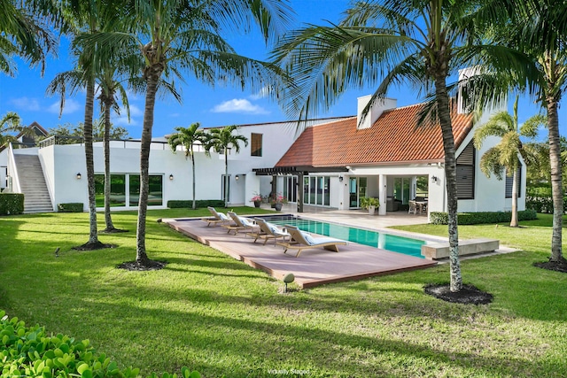 back of house featuring a lawn and a patio area