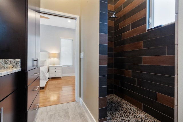 bathroom with vanity, wood-type flooring, and tiled shower