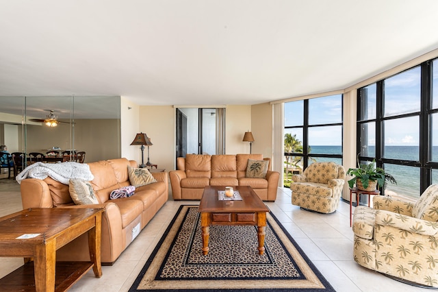 tiled living room with a wall of windows, a water view, and ceiling fan