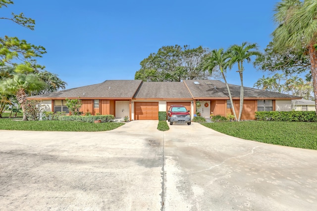 ranch-style house with a garage and a front yard