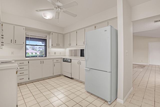 kitchen with white cabinets, light tile patterned floors, and white appliances