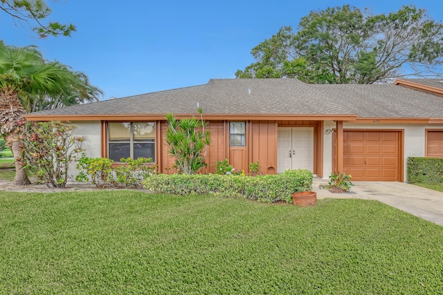 ranch-style home featuring a garage and a front lawn