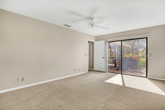 carpeted empty room featuring ceiling fan and a textured ceiling