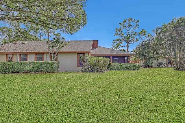 view of front of home featuring a front yard and a sunroom