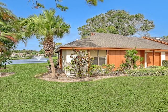 view of property exterior featuring a lawn and a water view