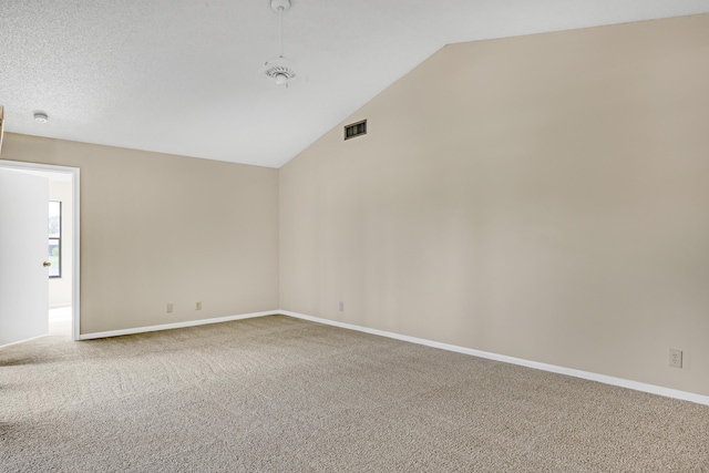 carpeted spare room with vaulted ceiling